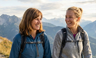 Two active women (35 and 45) on a hike, demonstrating the freedom of movement achieved through longevity-focused physical training.